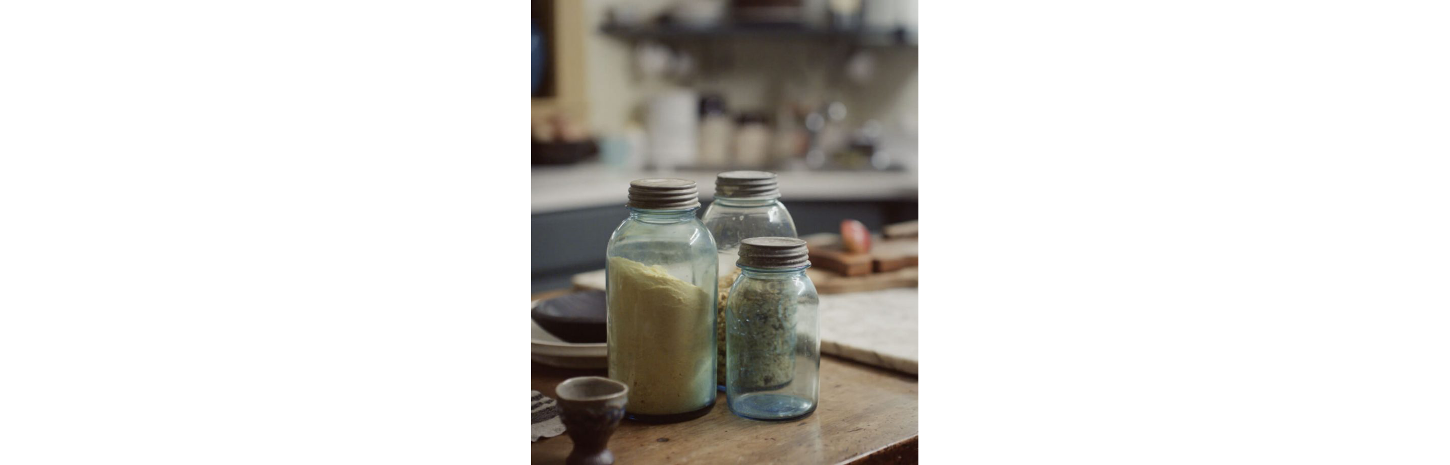 Three large, seasoning-filled jars resting on the kitchen counter.