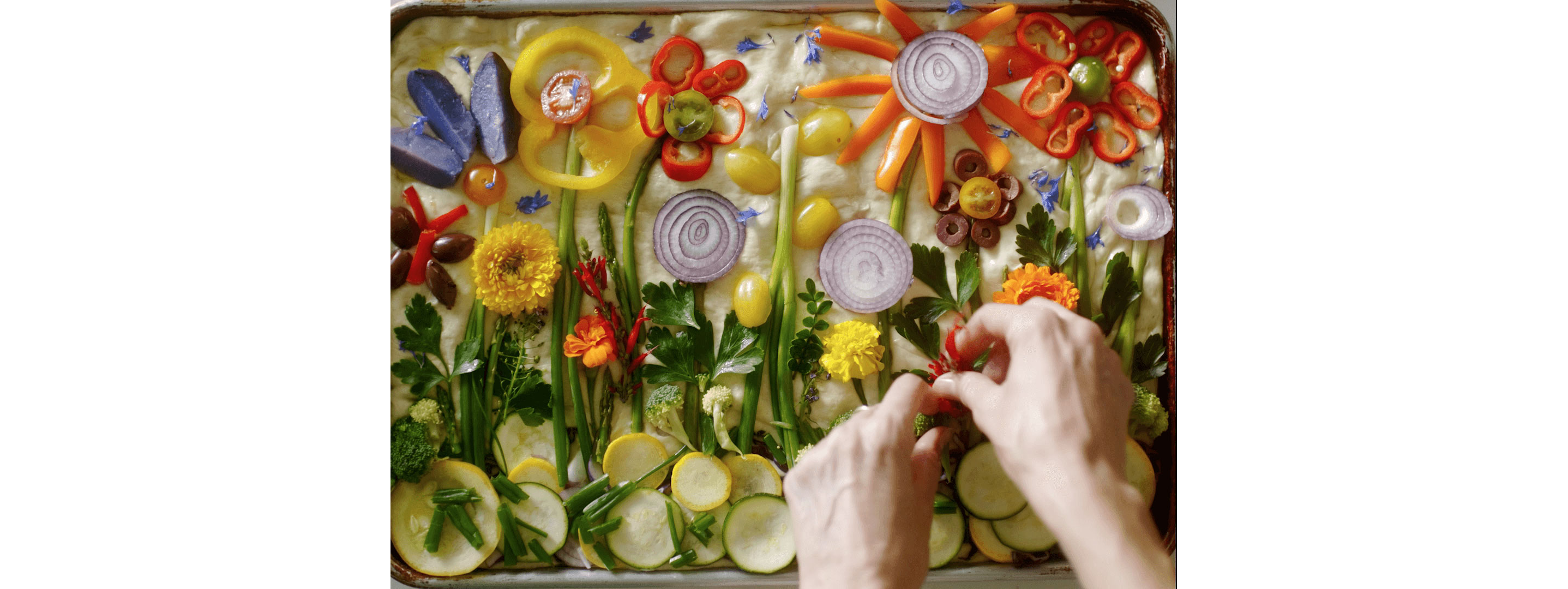 Loria Stern pressing edible flowers into focaccia bread.