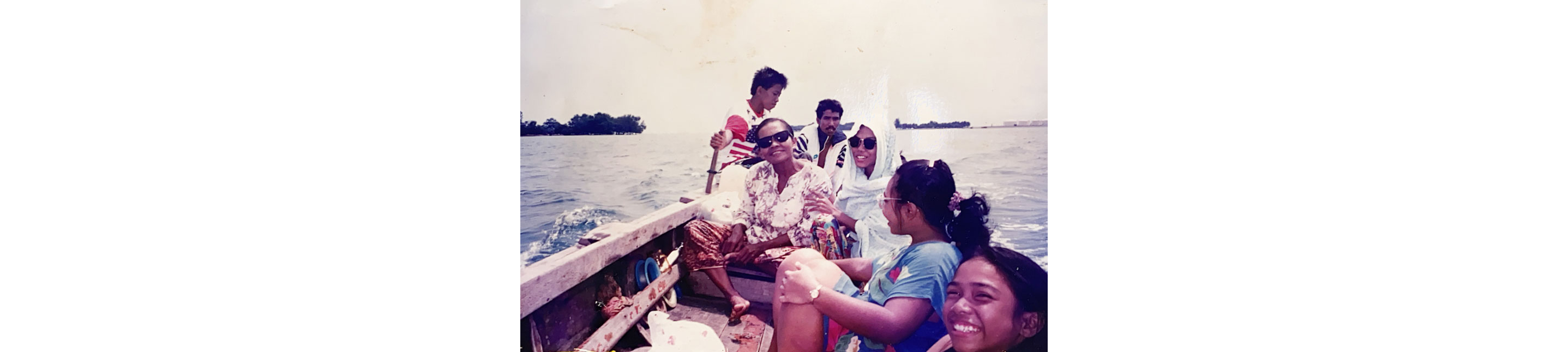 Firdaus Sani’s family posing for a picture on a boat.
