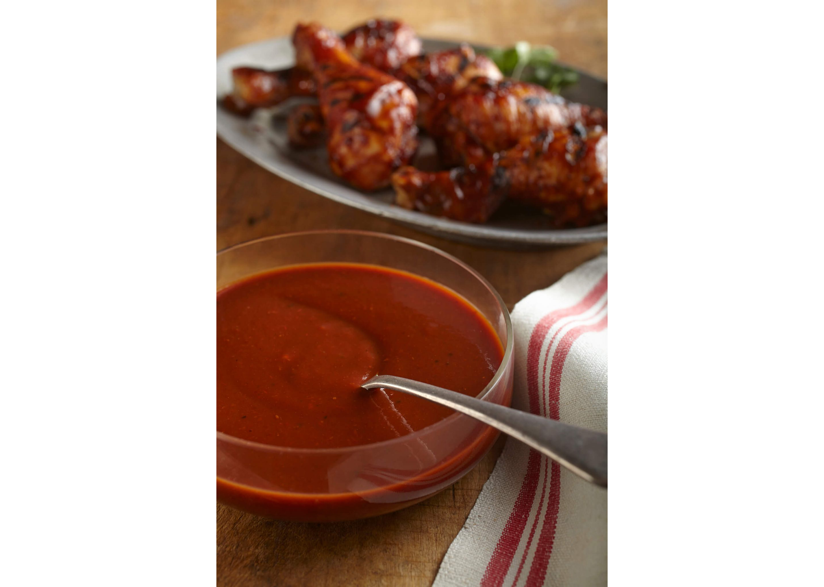 A small glass bowl filled with a homemade sauce for chicken wings.