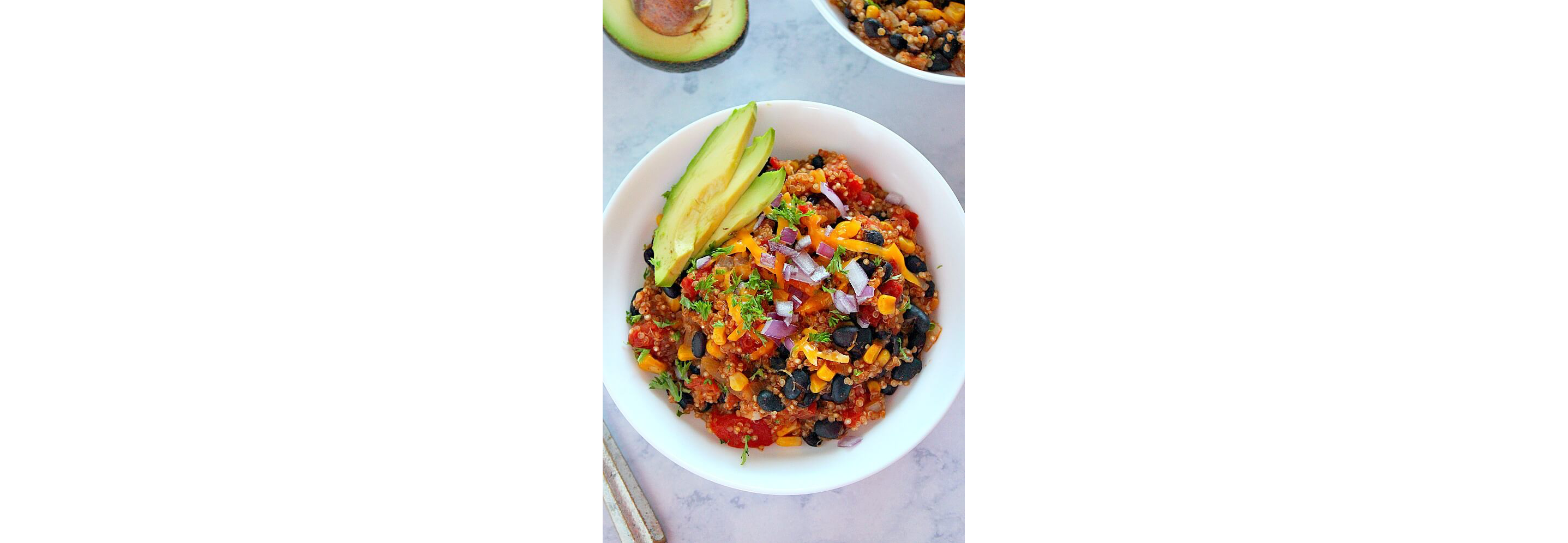 A bowl of colorful Tex-Mex cuisine with corn, avocado and other ingredients.