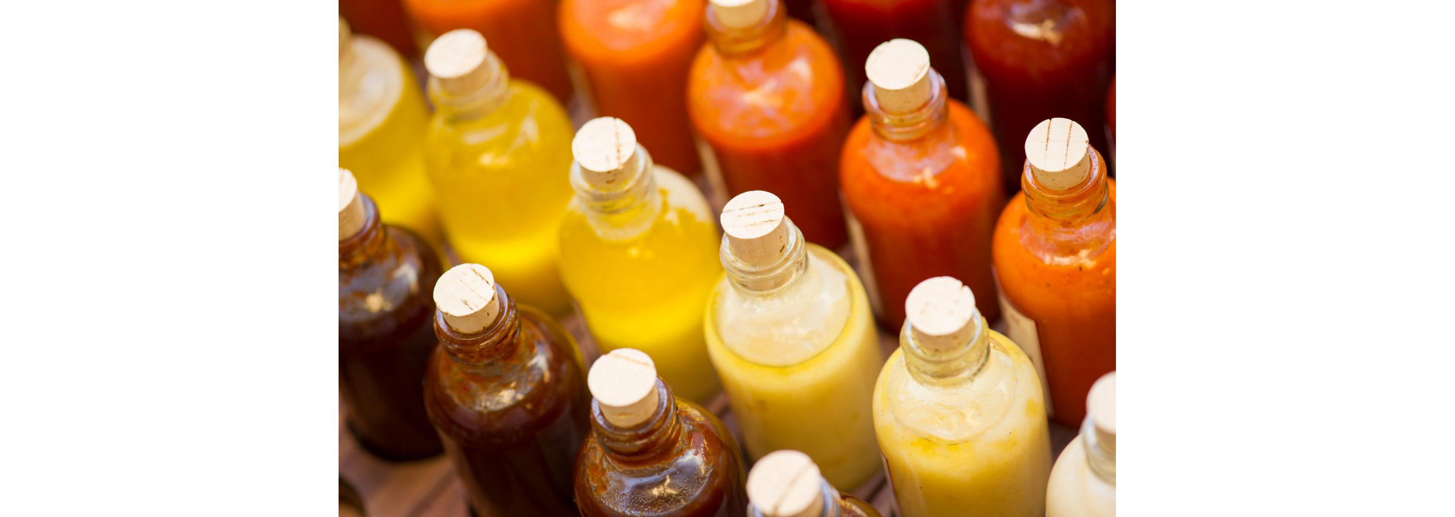 A variety of bottled sauces in a range of warm colors.