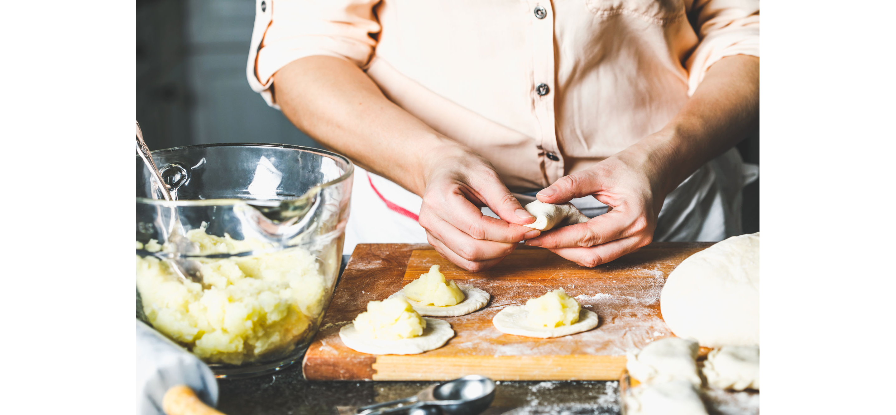 A person making fresh pierogies.