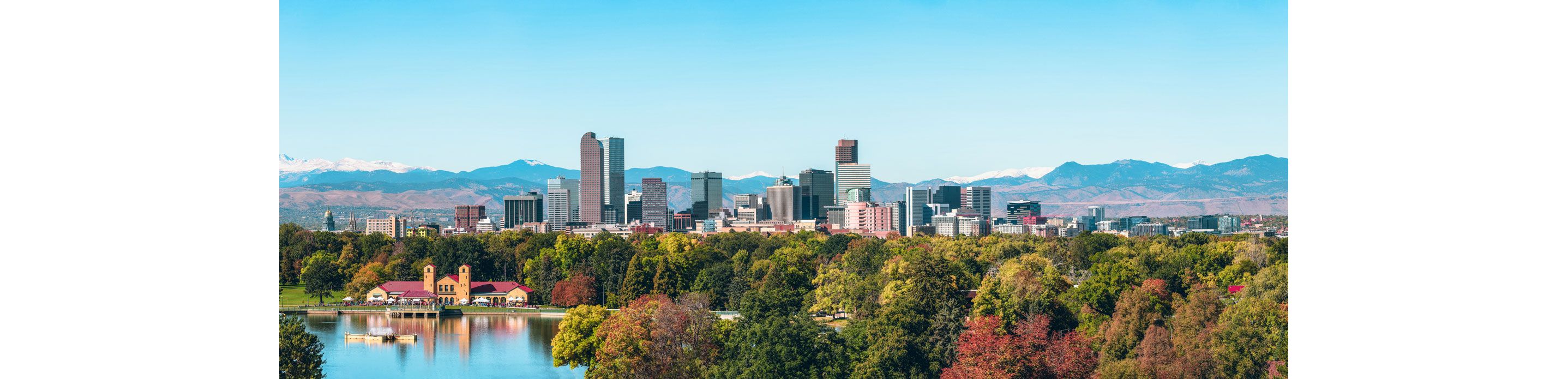 The city of Denver surrounded by picturesque mountains and colorful trees.