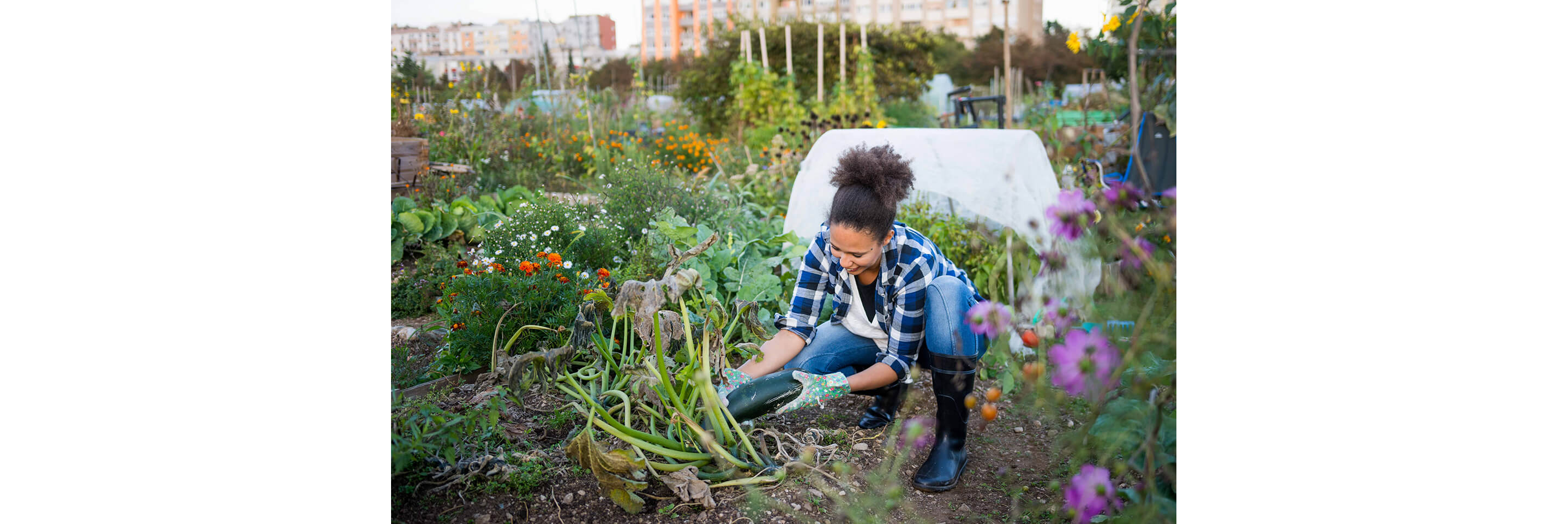 A young woman happily tending to her garden.