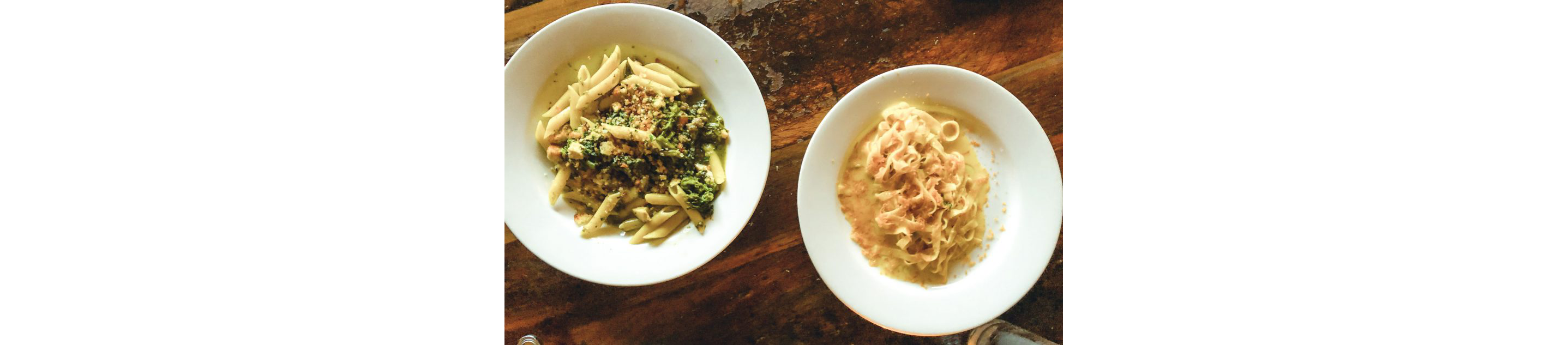 Two white dishes filled with freshly made pasta.