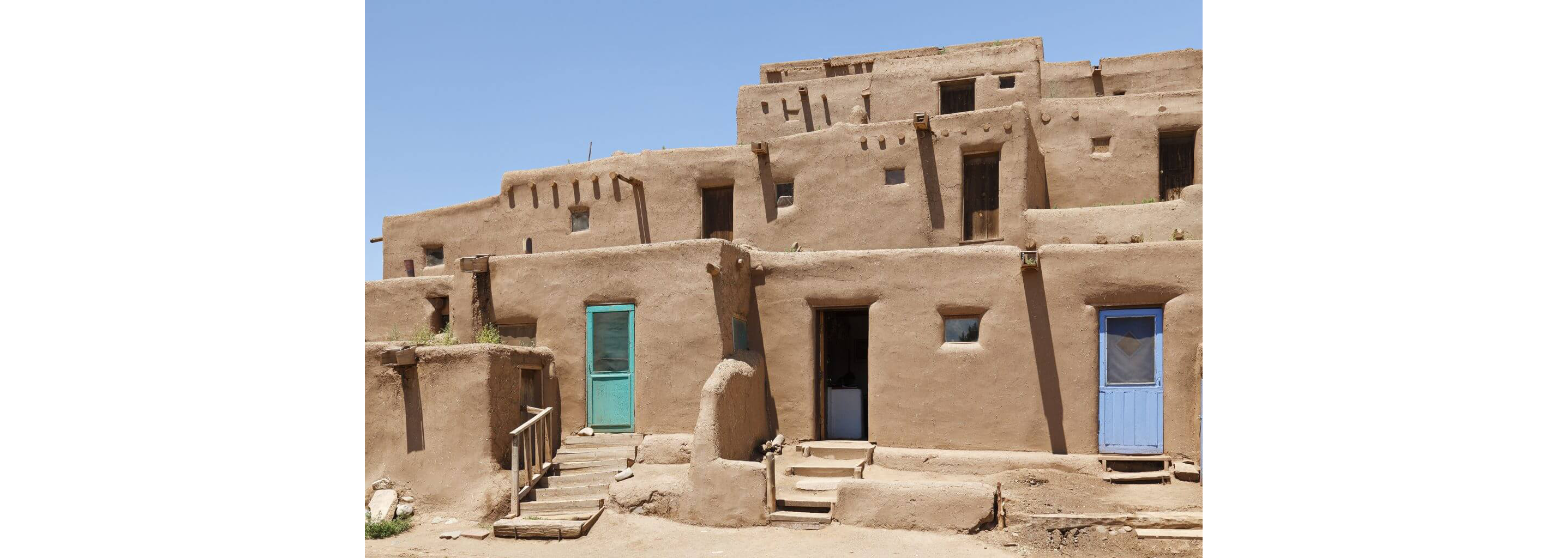 Historic adobe households engulfed bright in sunlight.