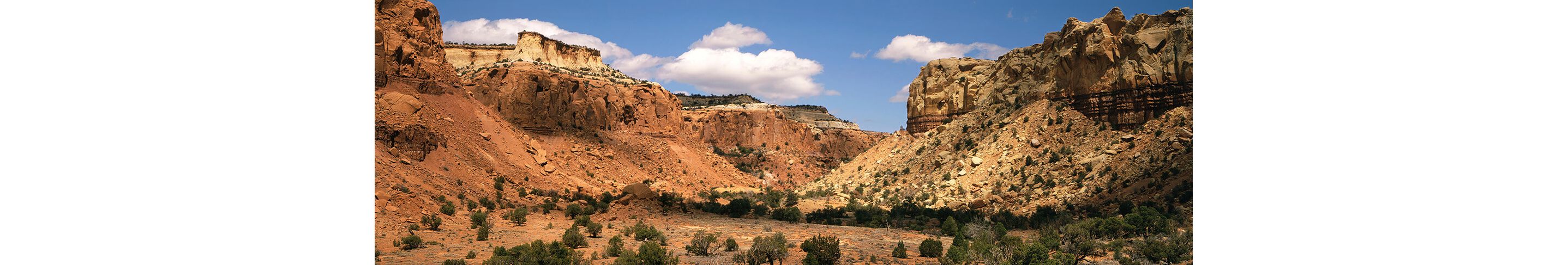 Santa Fe's red rock formations under a sunny, blue sky.