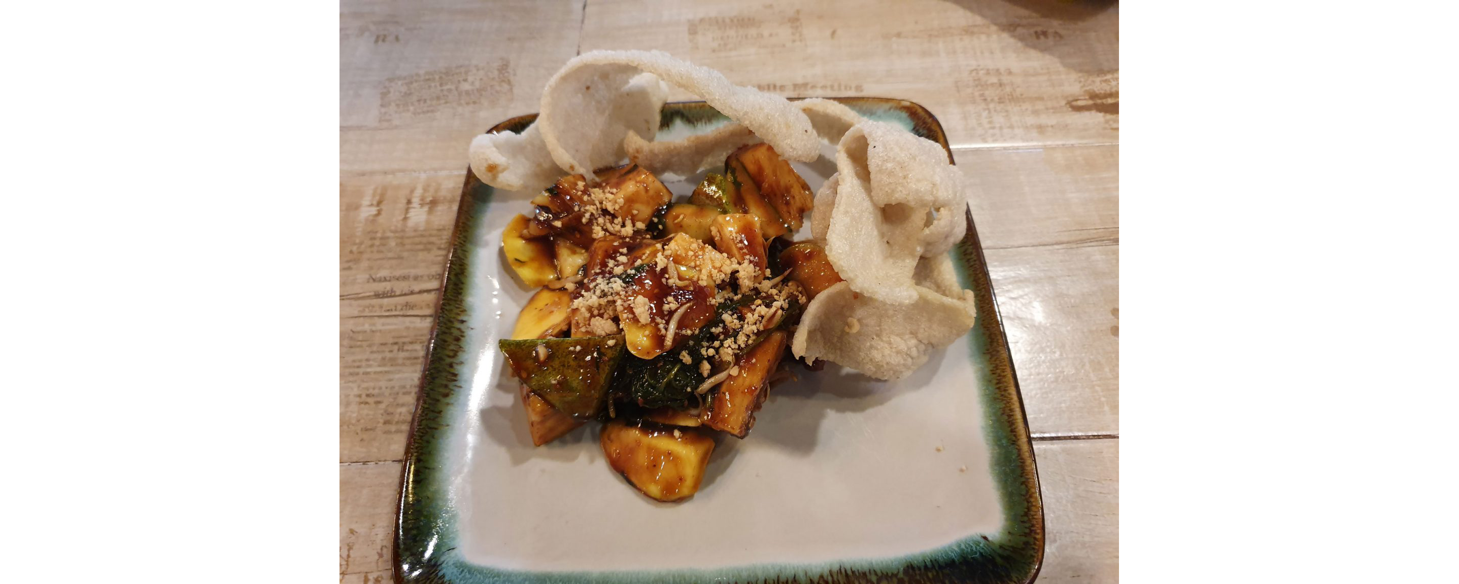 A square, ornate dish filled with vegetable rojak.