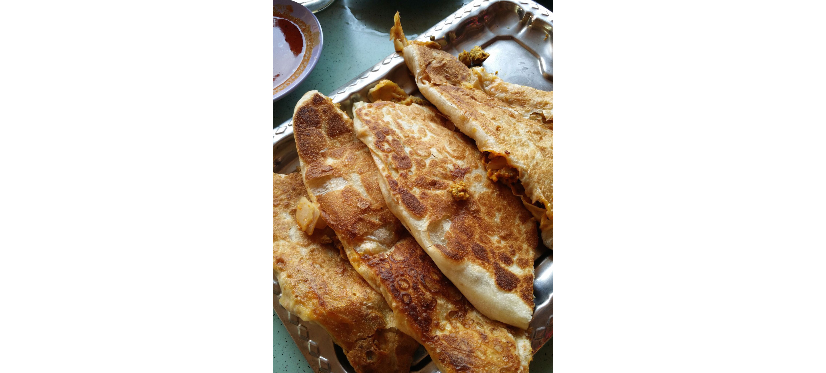 A silver plate filled with Roti Prata.