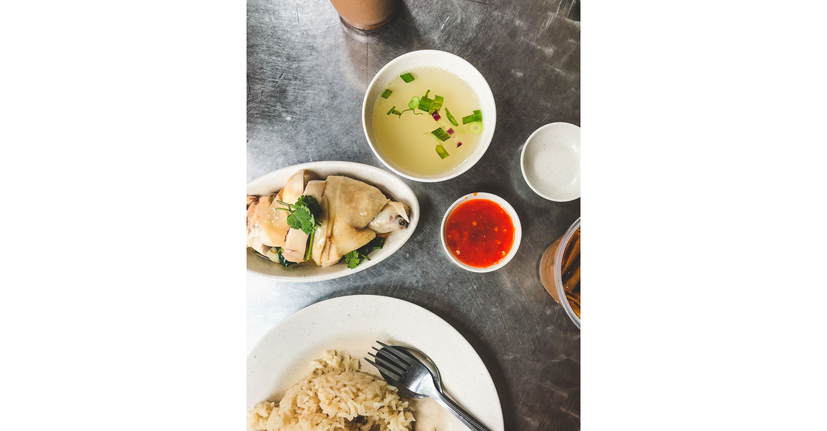 A variety of Singaporean dishes resting on a large, metal table.