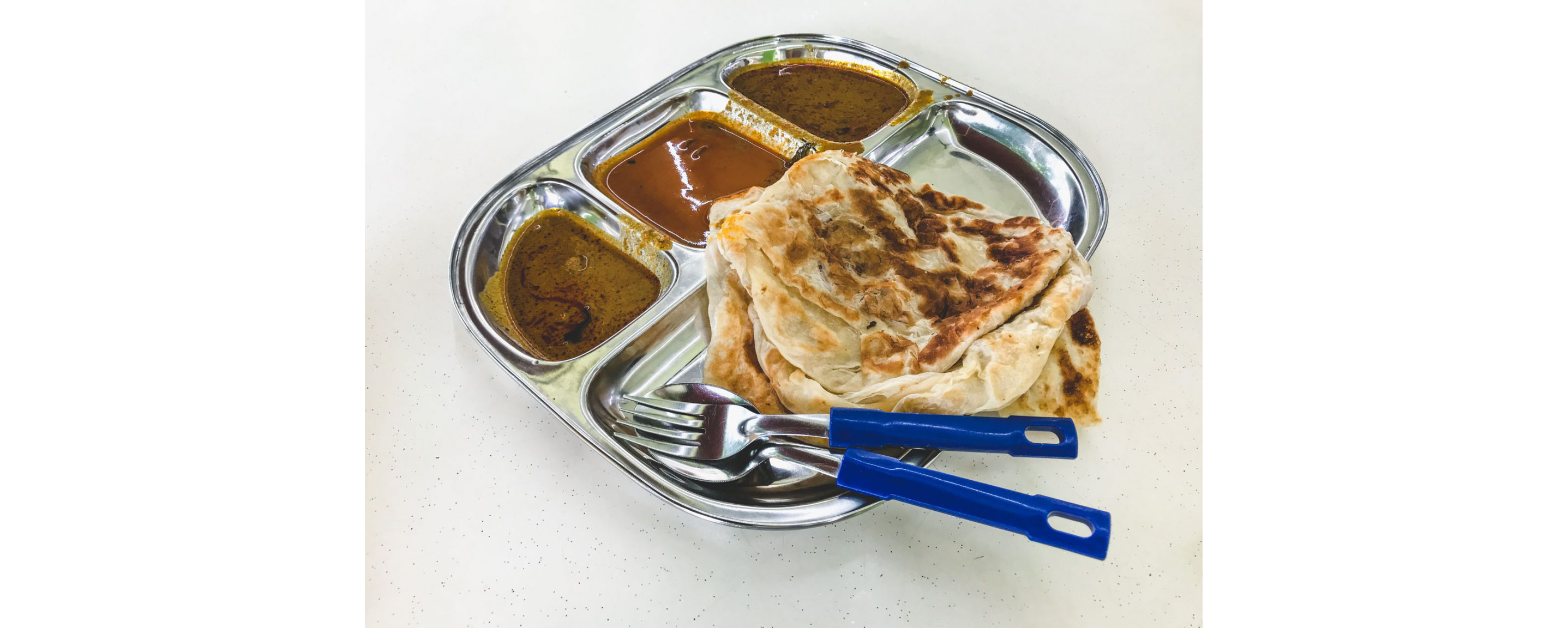 A silver tray filled with Roti John and a variety of sauces.