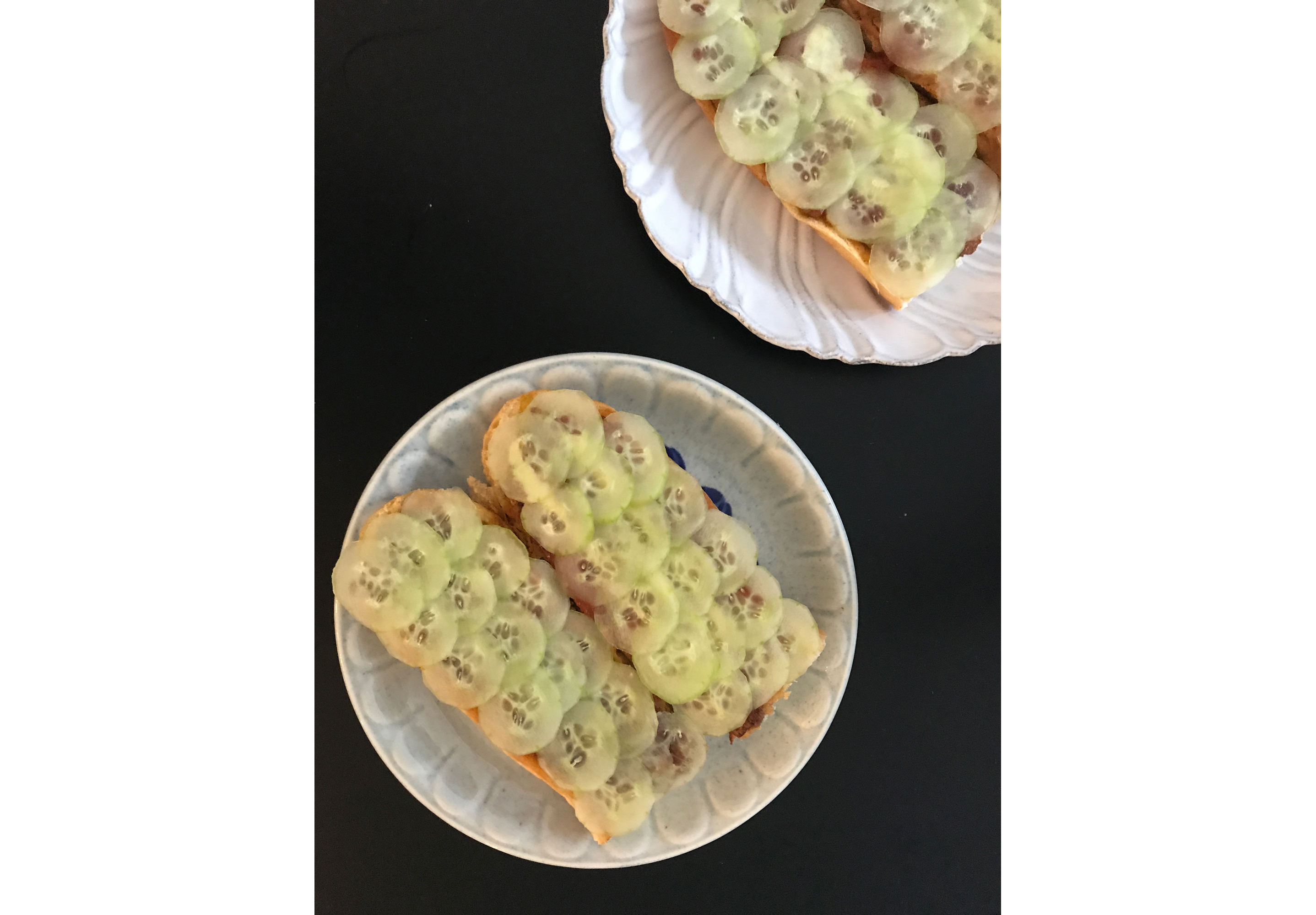 An open roti john filled with sliced cucumber.