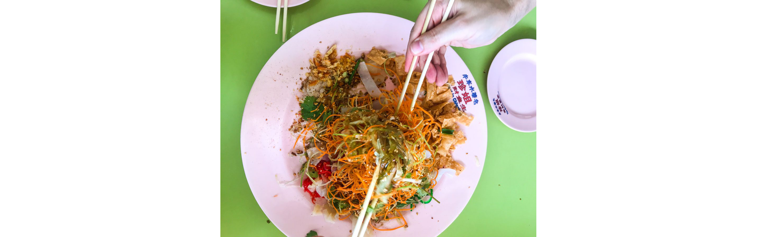Someone eating raw fish salad with chopsticks.