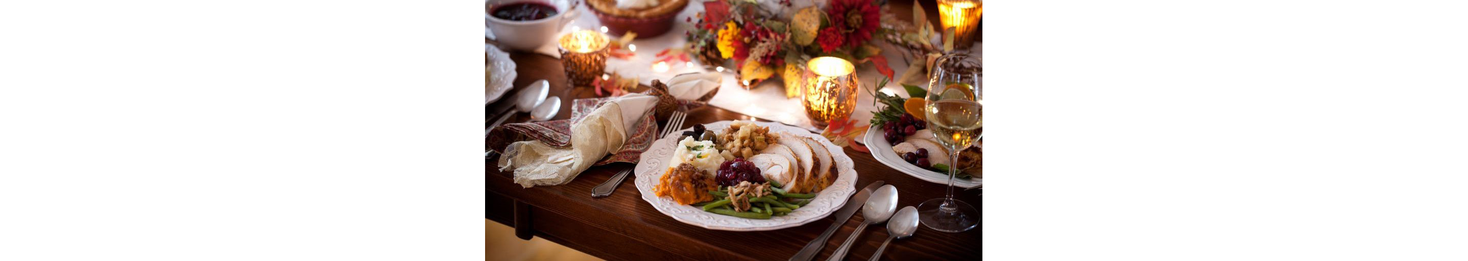 A festive table with dinner plate filled with delicious eats.
