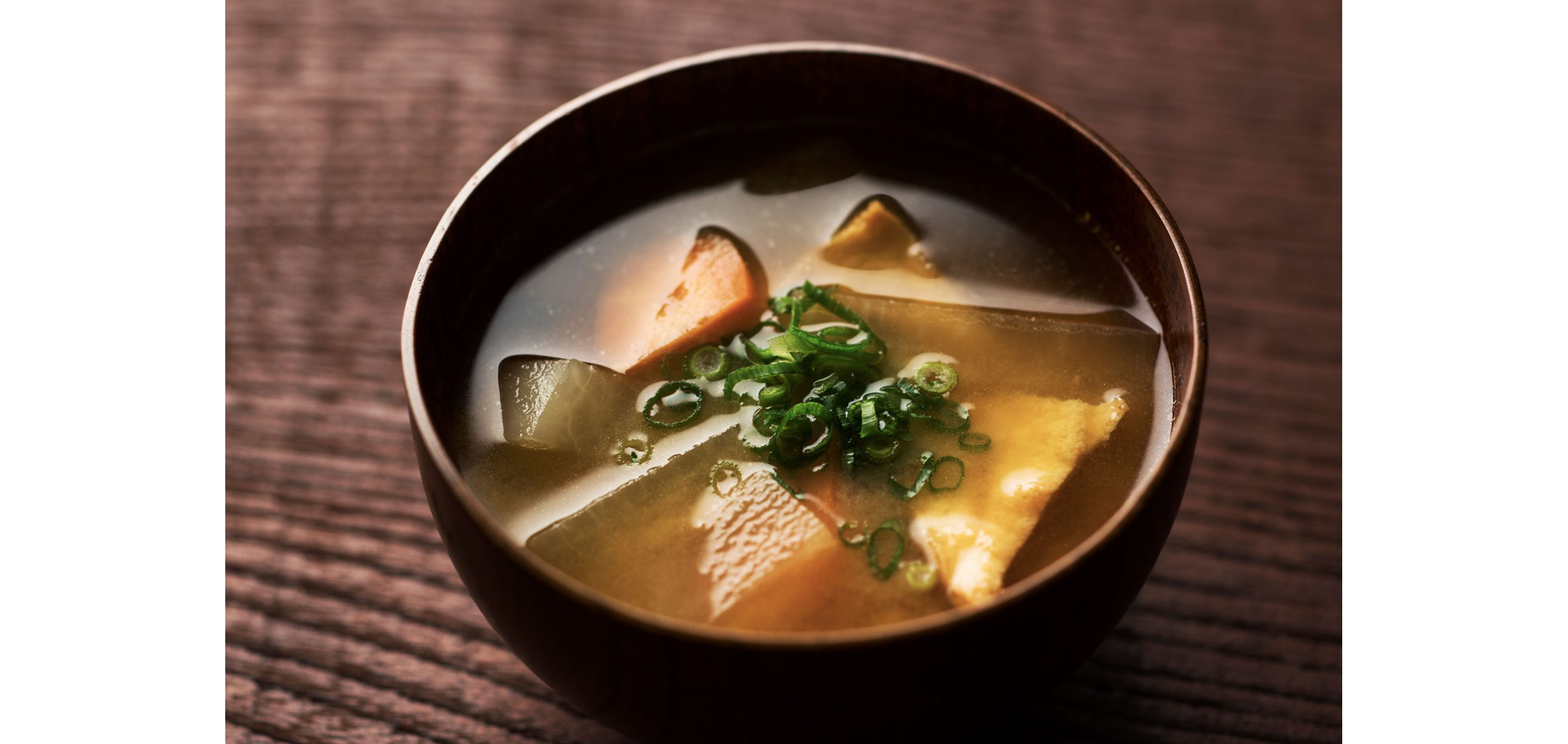 A wooden bowl filled with miso soup made with green tea.