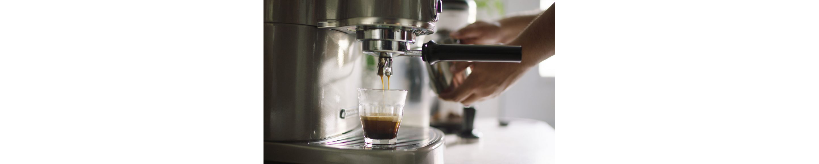 A person making espresso with a KitchenAid® Pro Line® Series Espresso Maker.