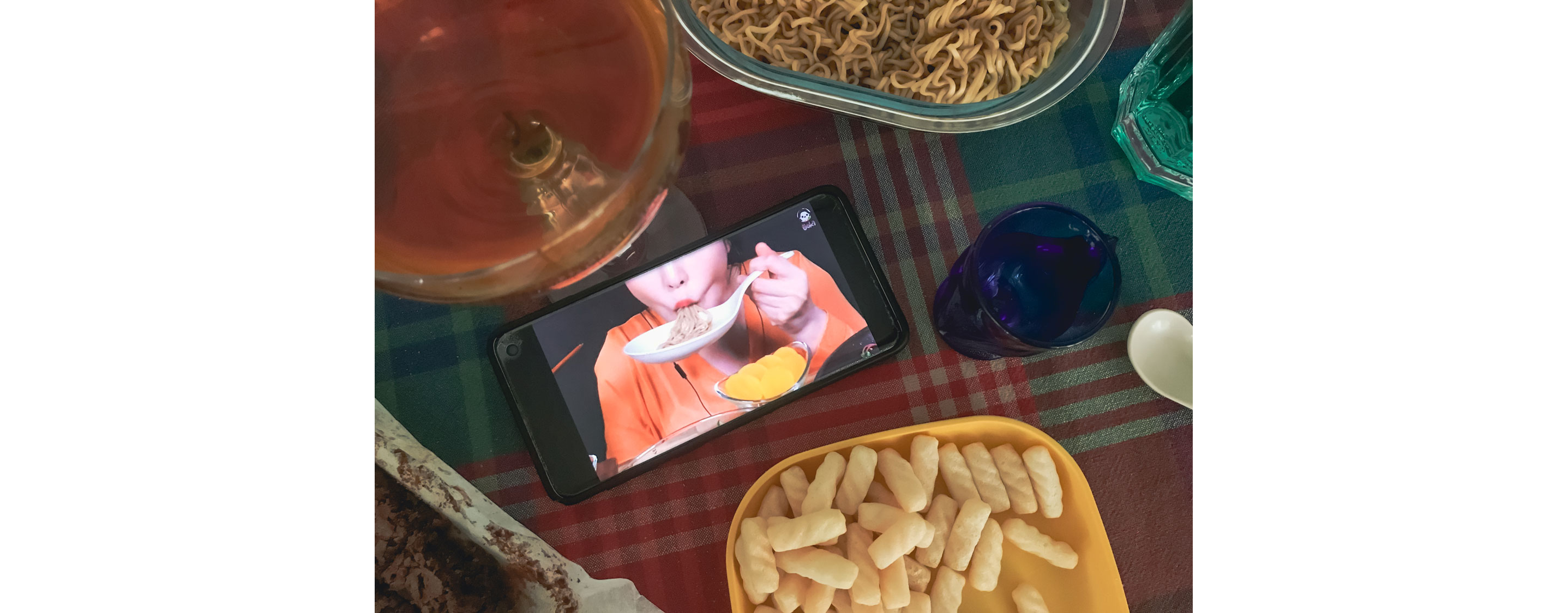 An open smart phone featuring a person eating.