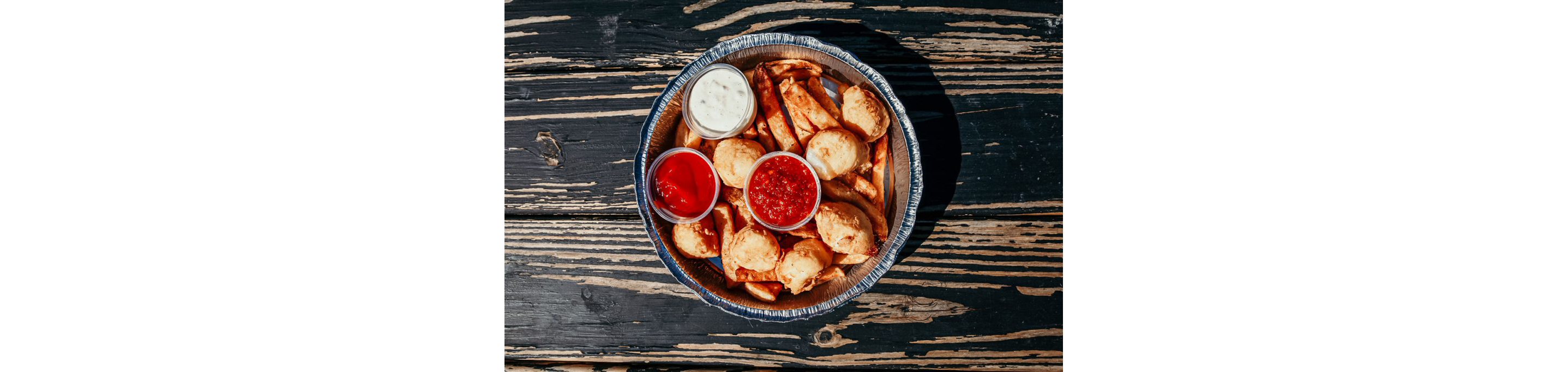 A dish filled with fried clam strips and various sauces.