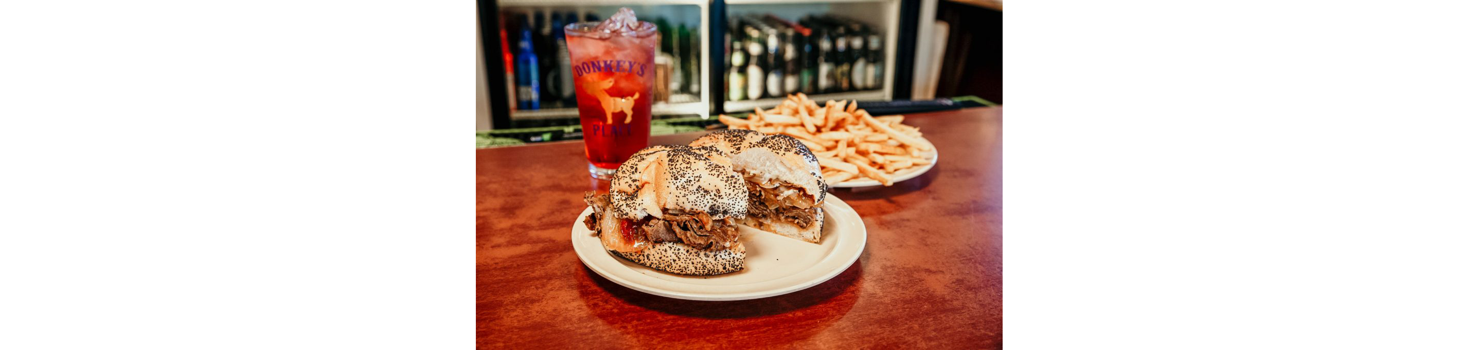 A plate of a Donkey's Place cheesesteak and french fries.