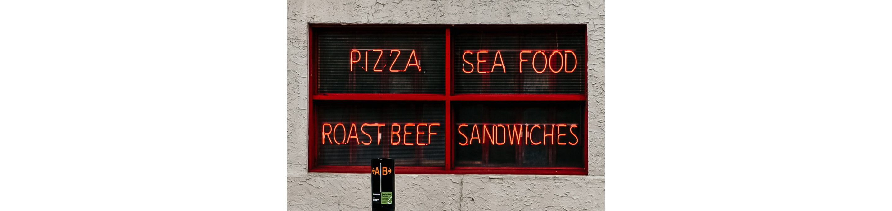 Four red neon signs displaying various types of food.