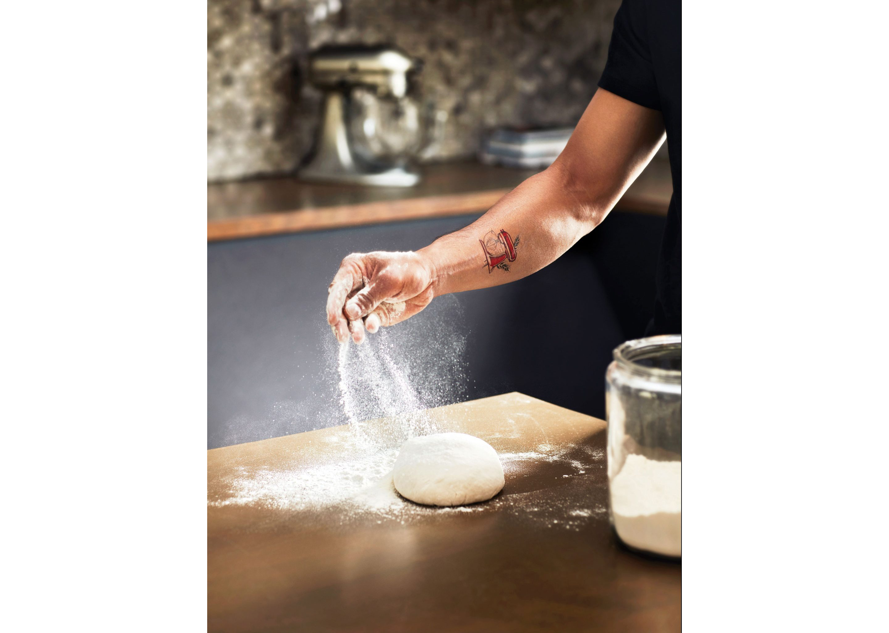 A person sprinkling flour on fresh dough.