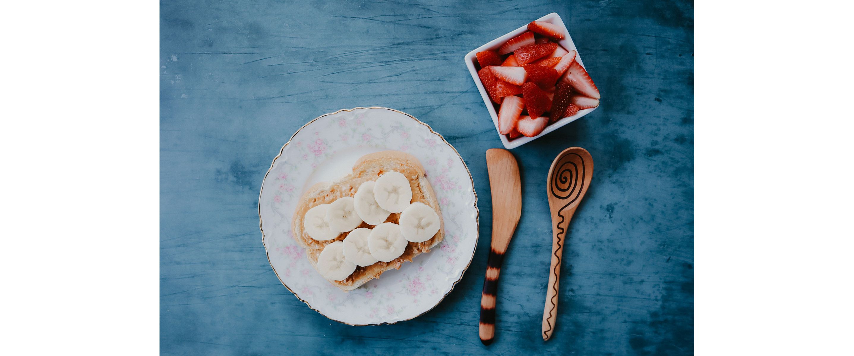 A delicate plate of food paired with intracate wooden utensils.