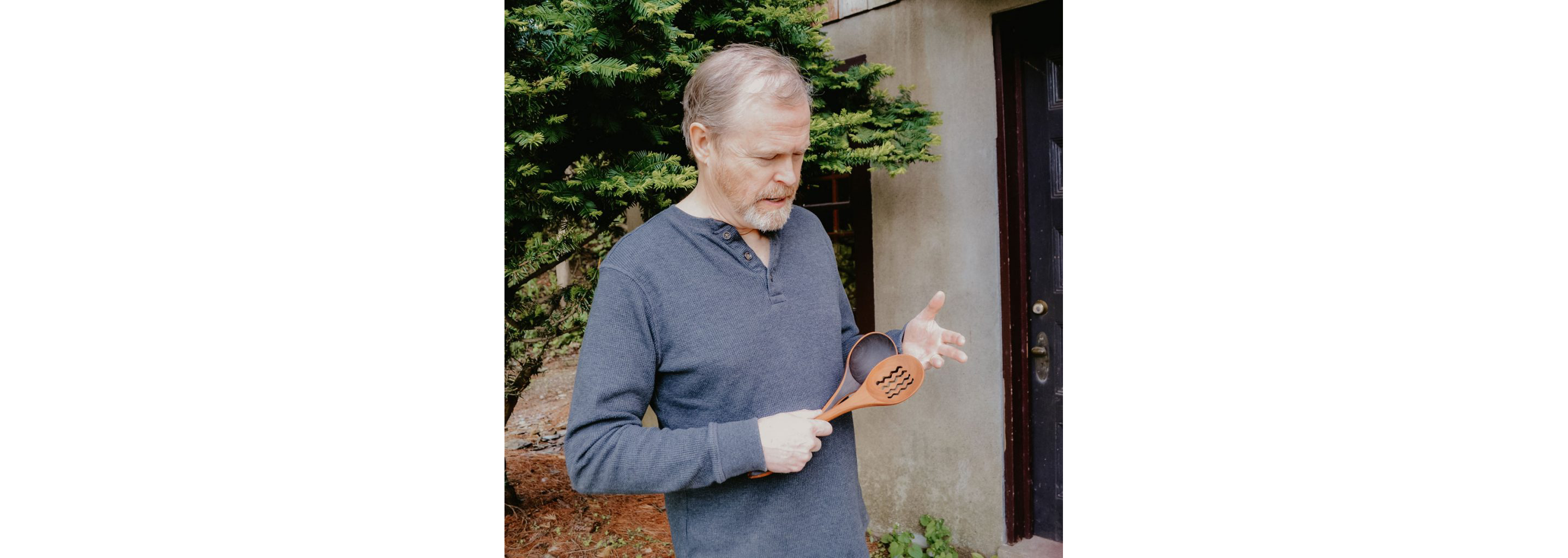 Jonathan Simons holding two wooden utensils.