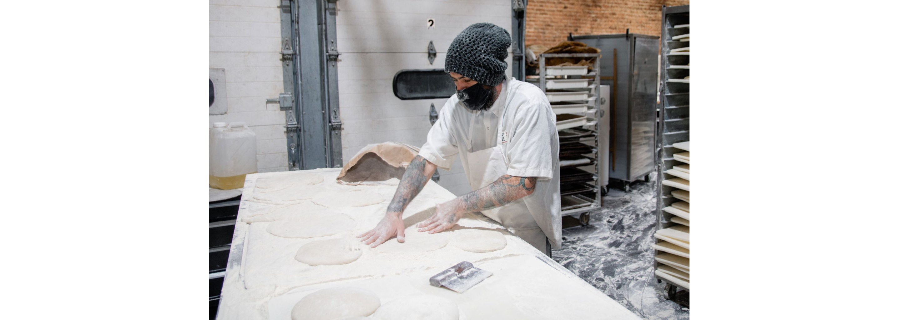 A person pressing against mounds of dough.