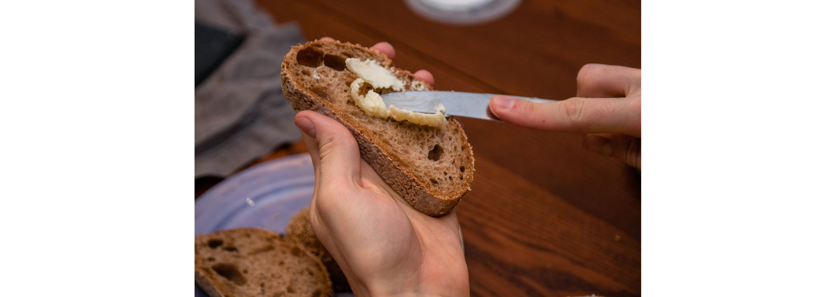 A person buttering a slice of bread.