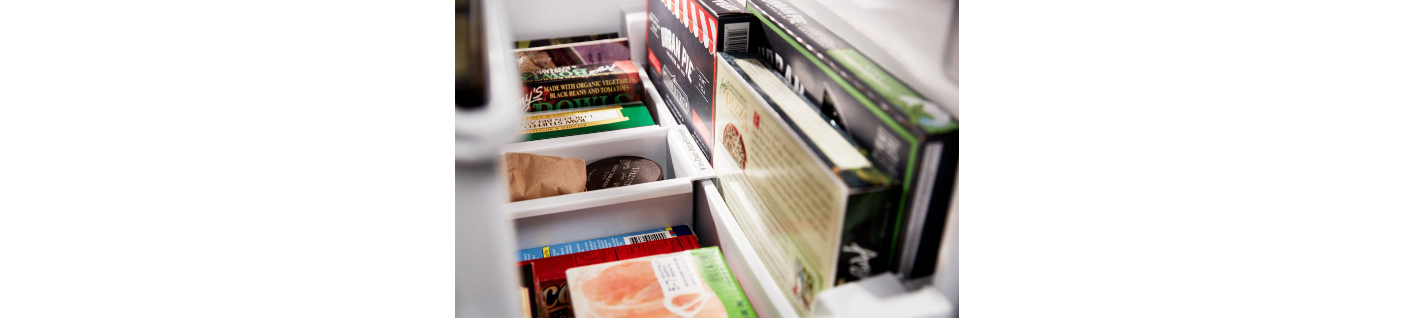 A freezer filled with a variety of frozen food boxes and containers.