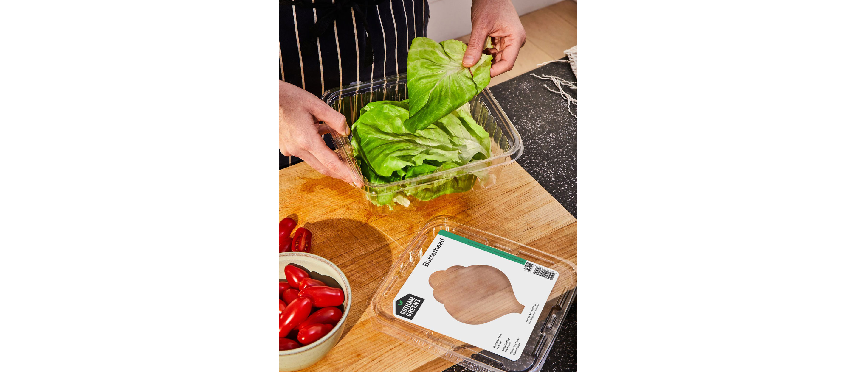A person selecting a leafy green from a container.