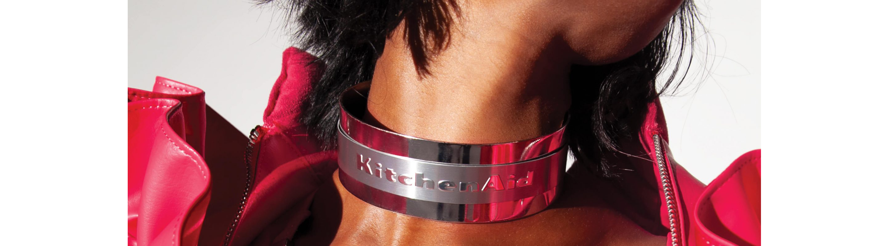 A close up of the KitchenAid® logo on the choker necklace of a model.
