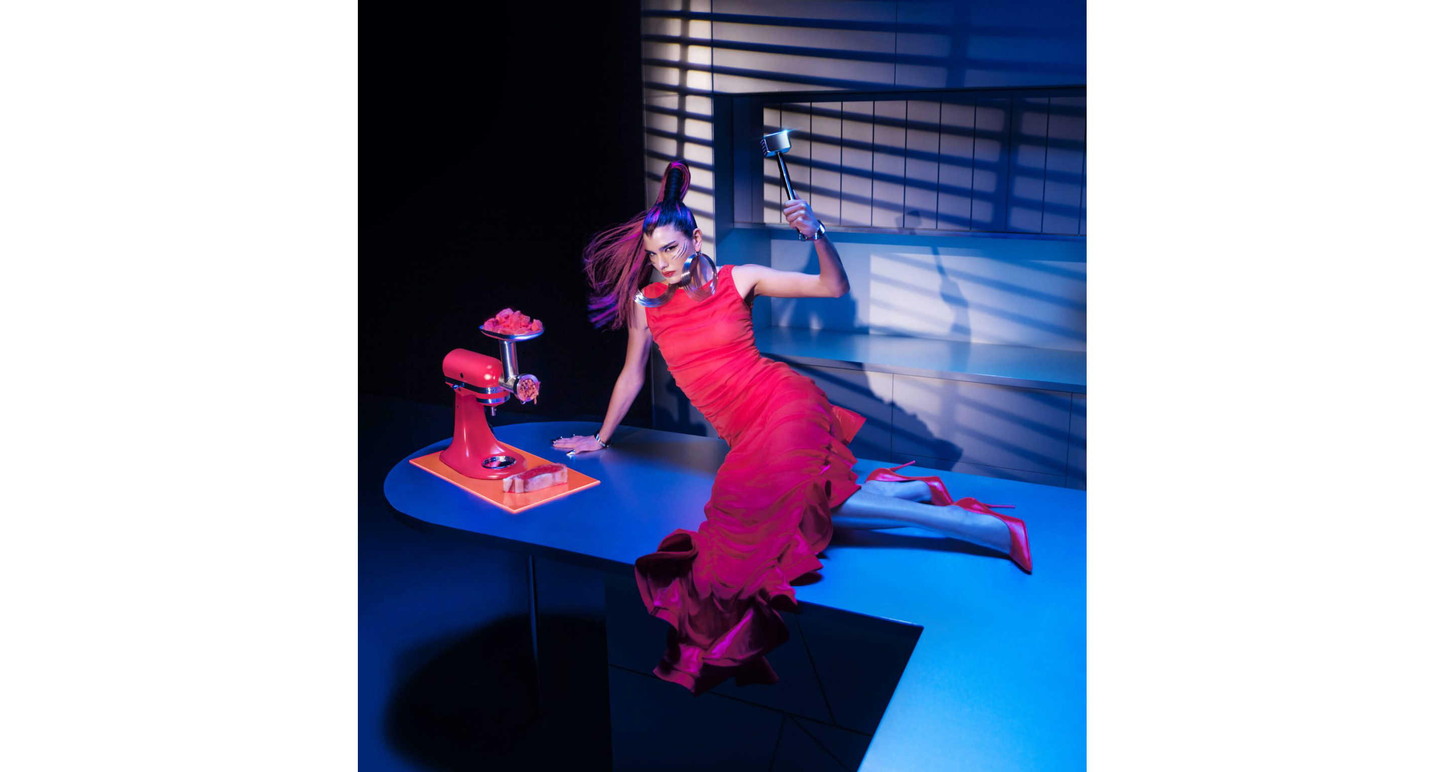 A model posing in a kitchen wearing Look Eight near the Artisan® Series Stand Mixer on an island using the meat grinder attachment.