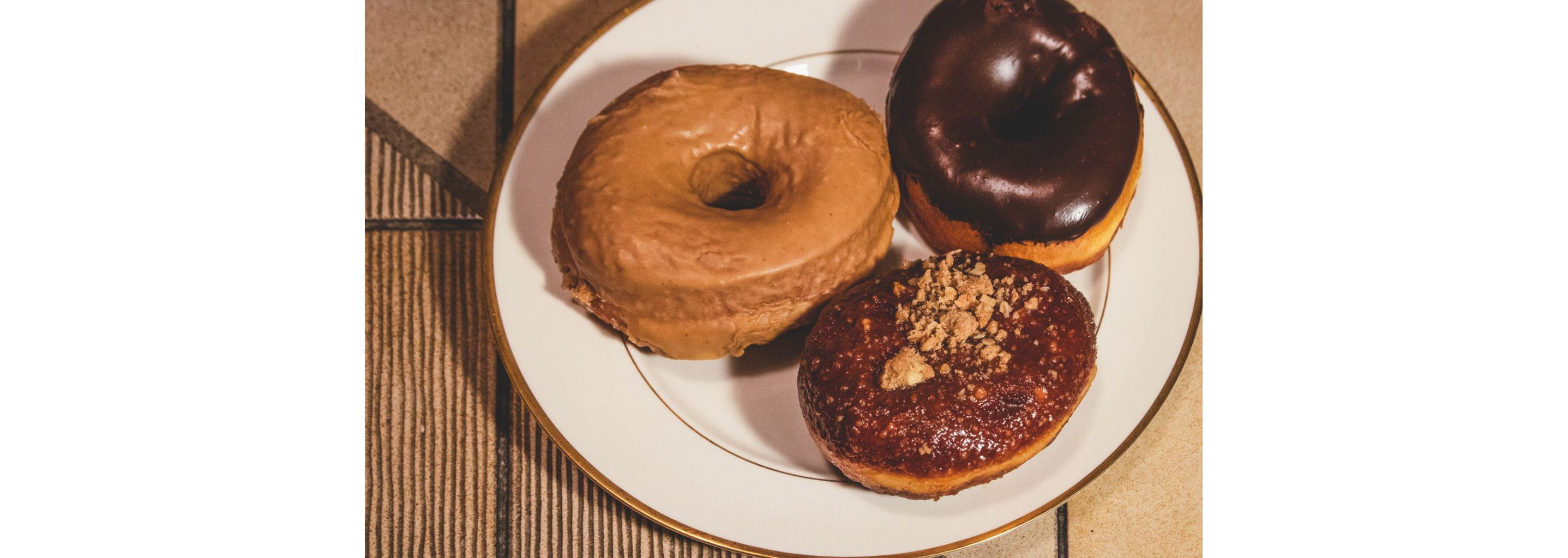 Donuts resting on a white plate.