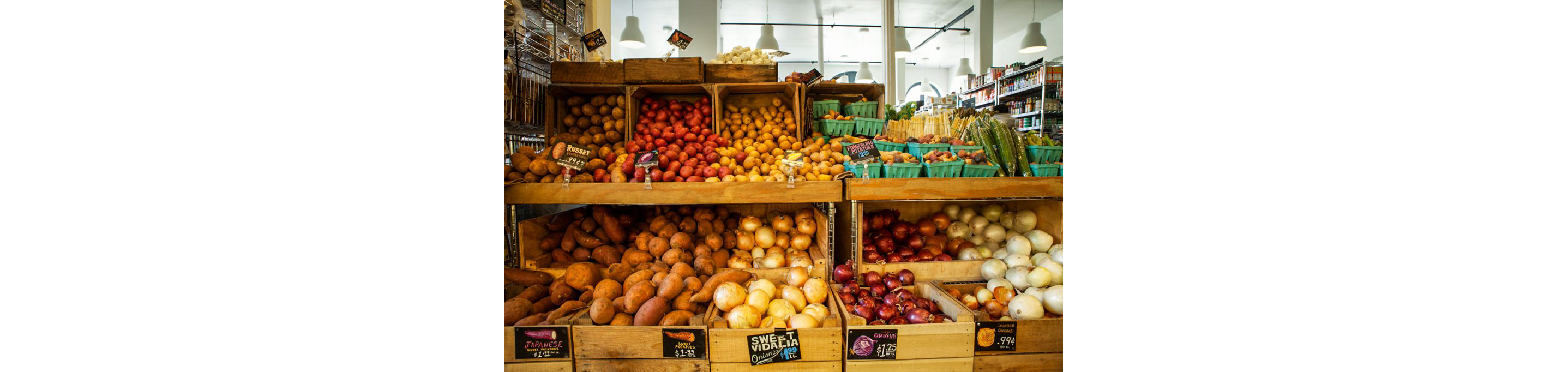 Potatoes and onions neatly displayed in wooden crates.