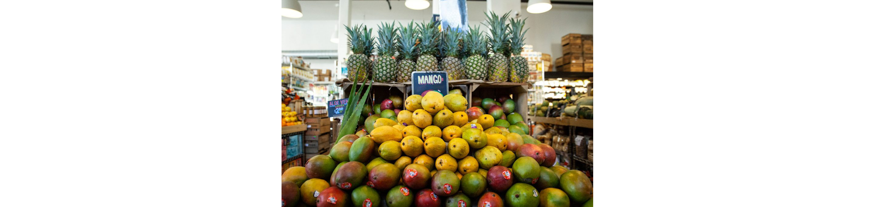 Piles of mangoes and pineapples out on display.