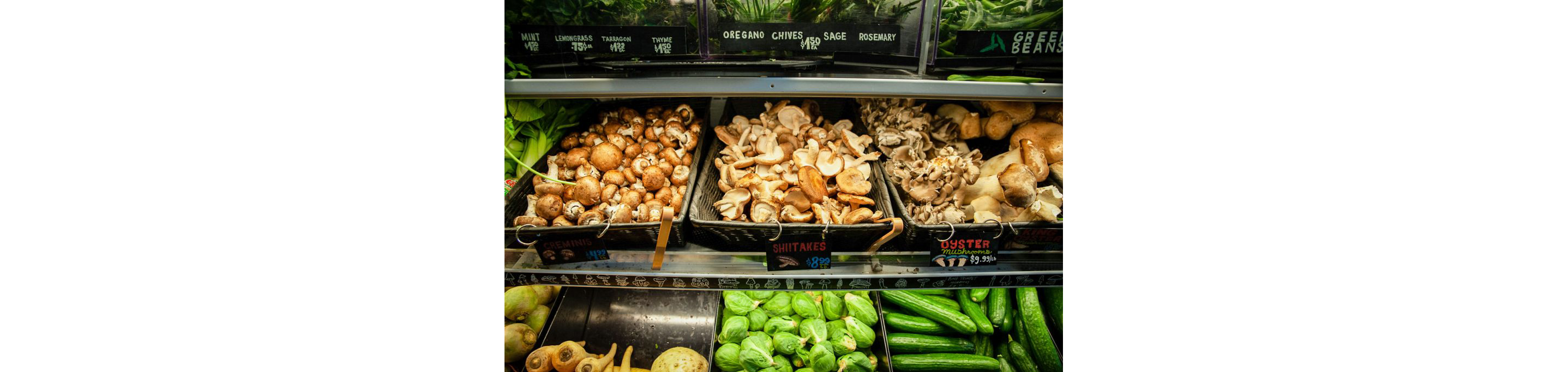 Several types of mushrooms displayed in woven baskets.