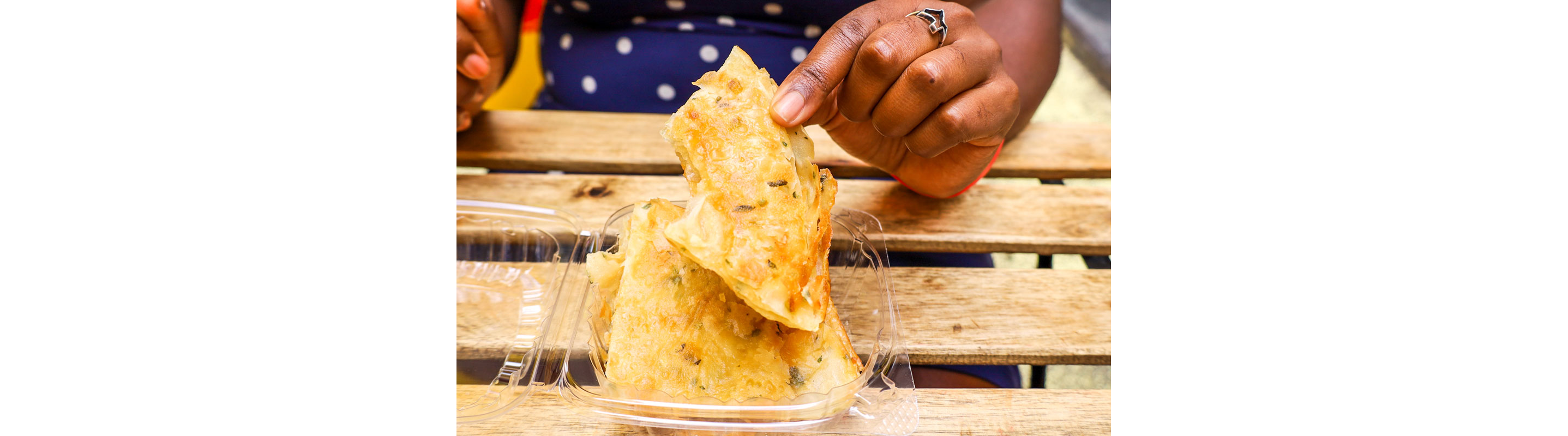 A person holding food from a clear container.