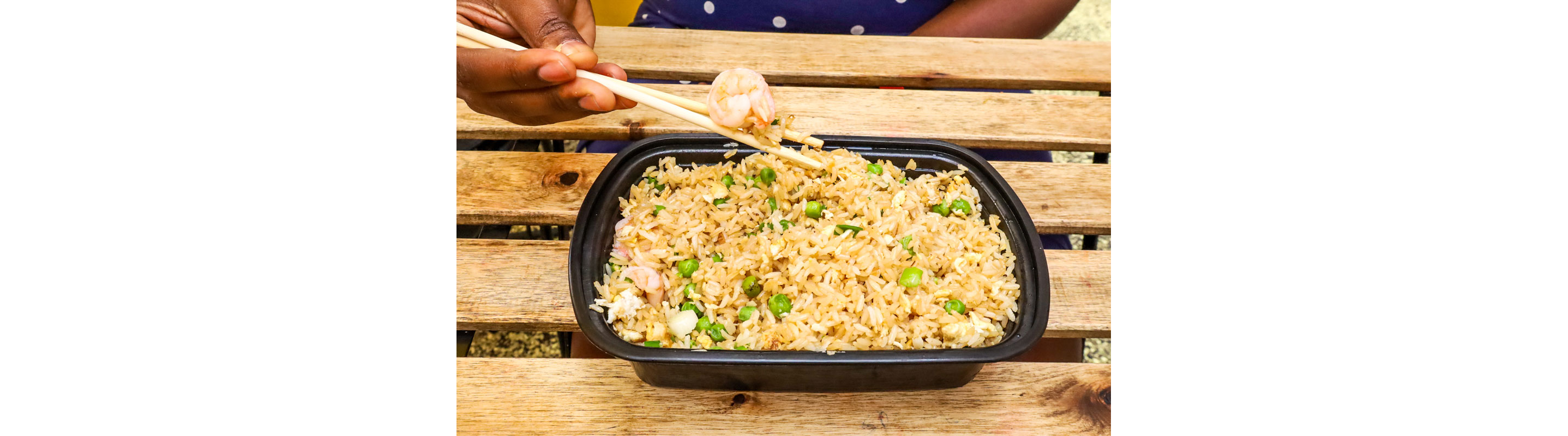 A black container filled with fried rice.
