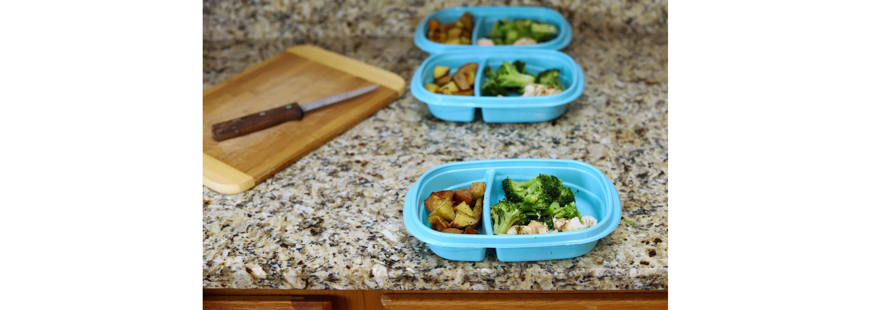 Three blue contaners being sorted for meal prepping.