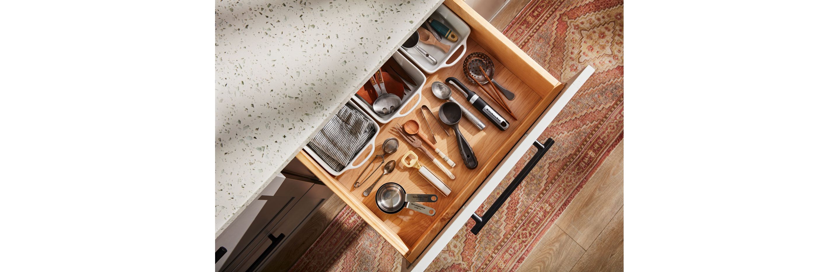 An open kitchen drawer filled with utensils neatly organized.