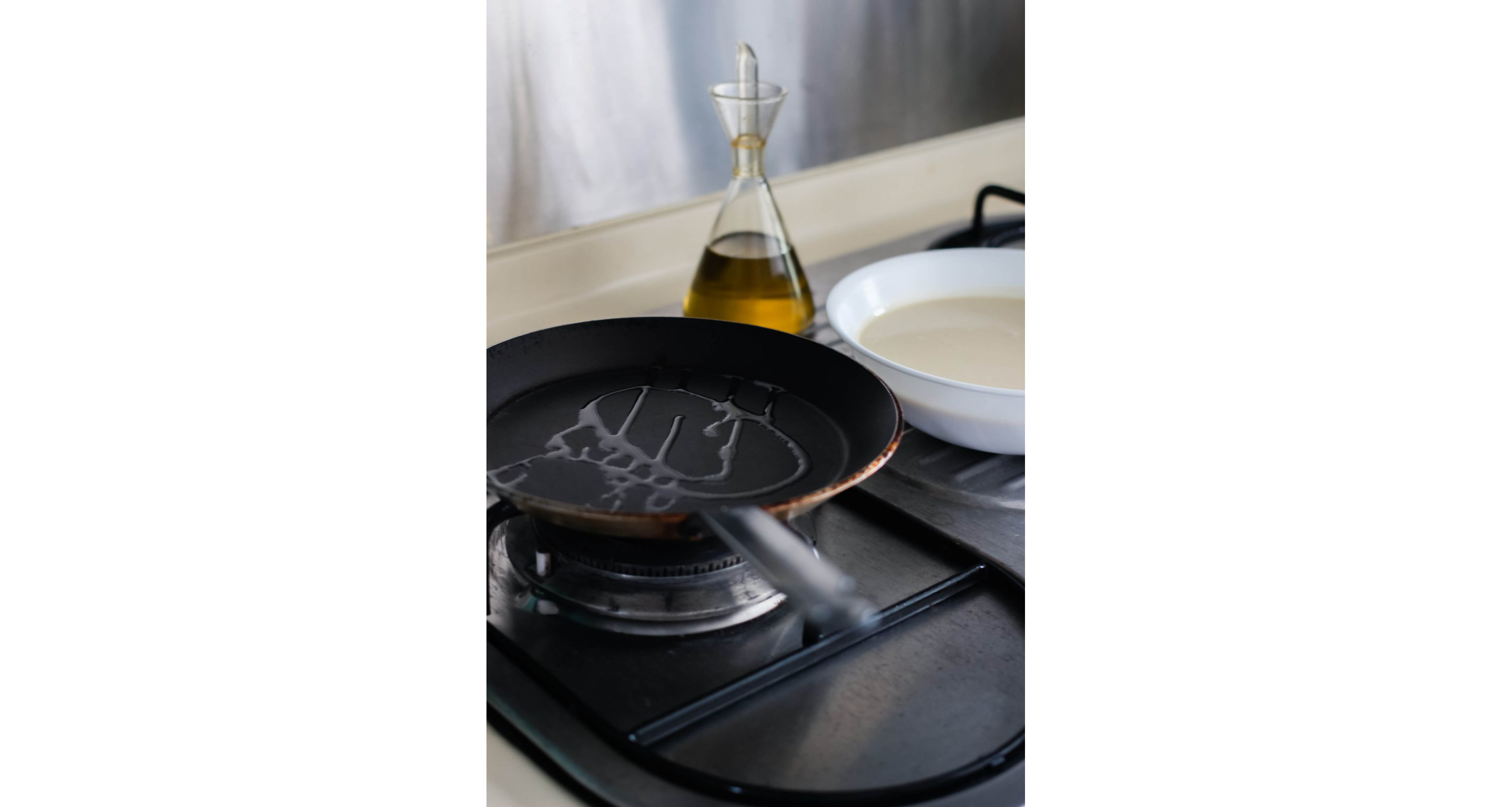 A small frying pan with a small drizzle of oil.