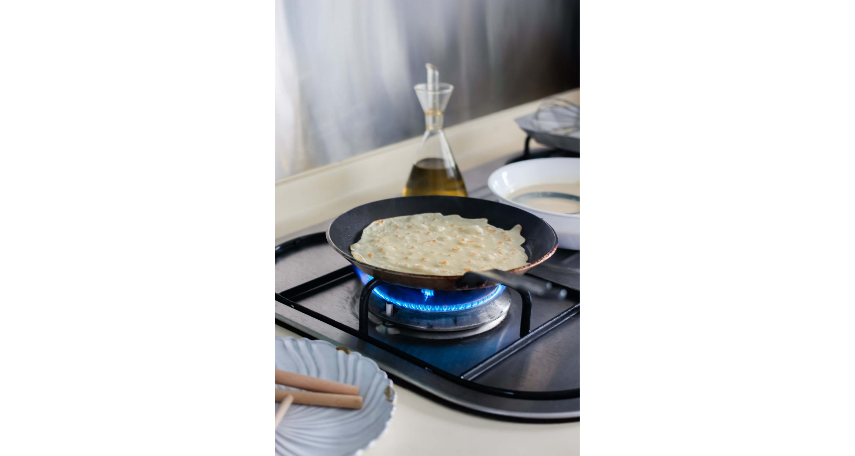 A pan cooking a crepe.