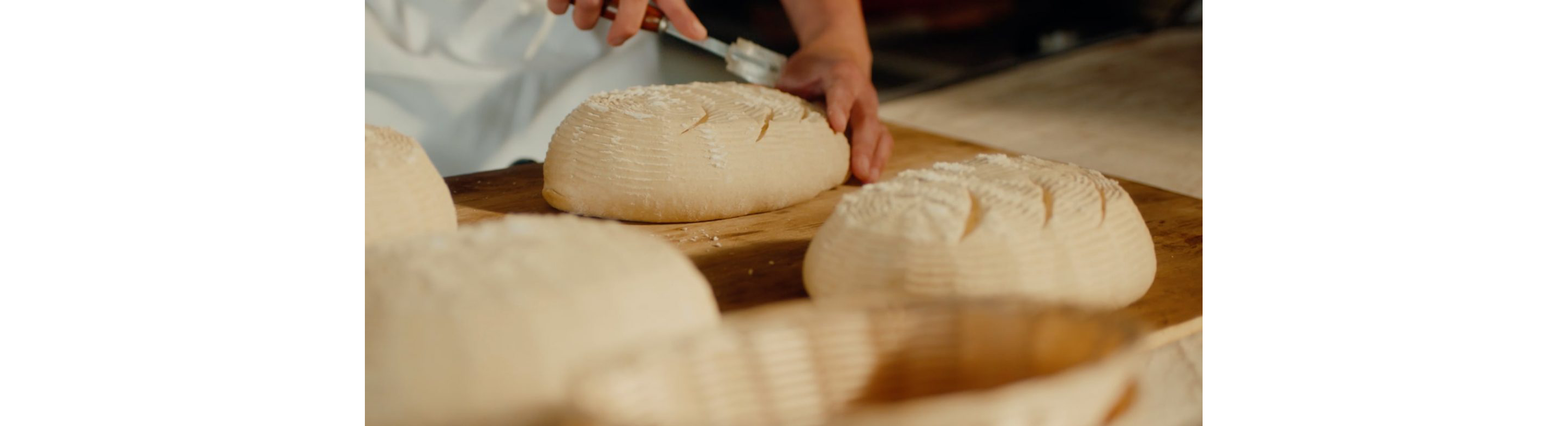 A person slicing into dough.