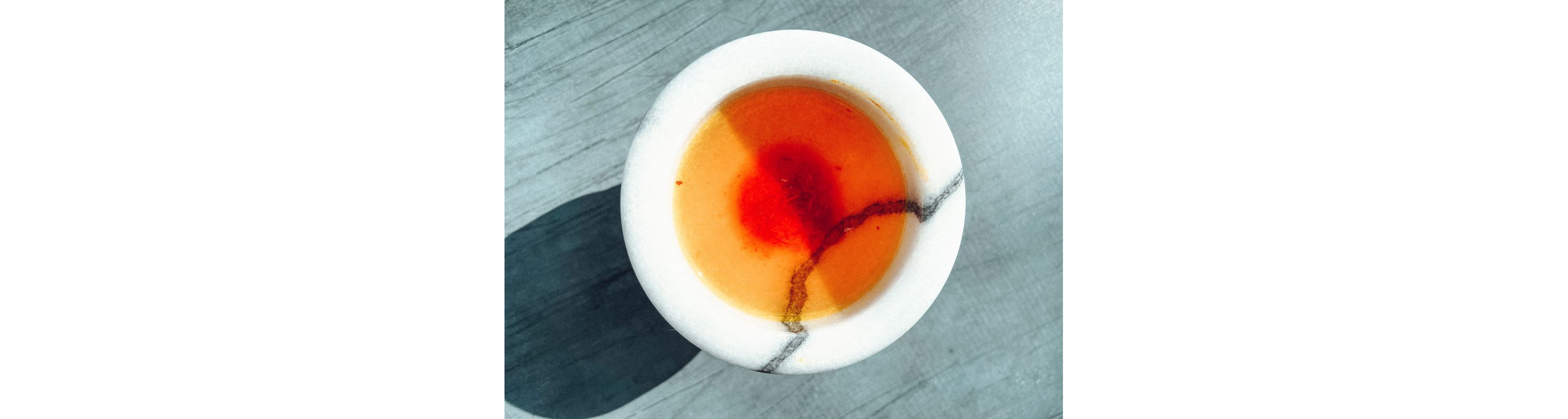 A small bowl of Gold Water: the liquid mixture of saffron, sugar and salt.