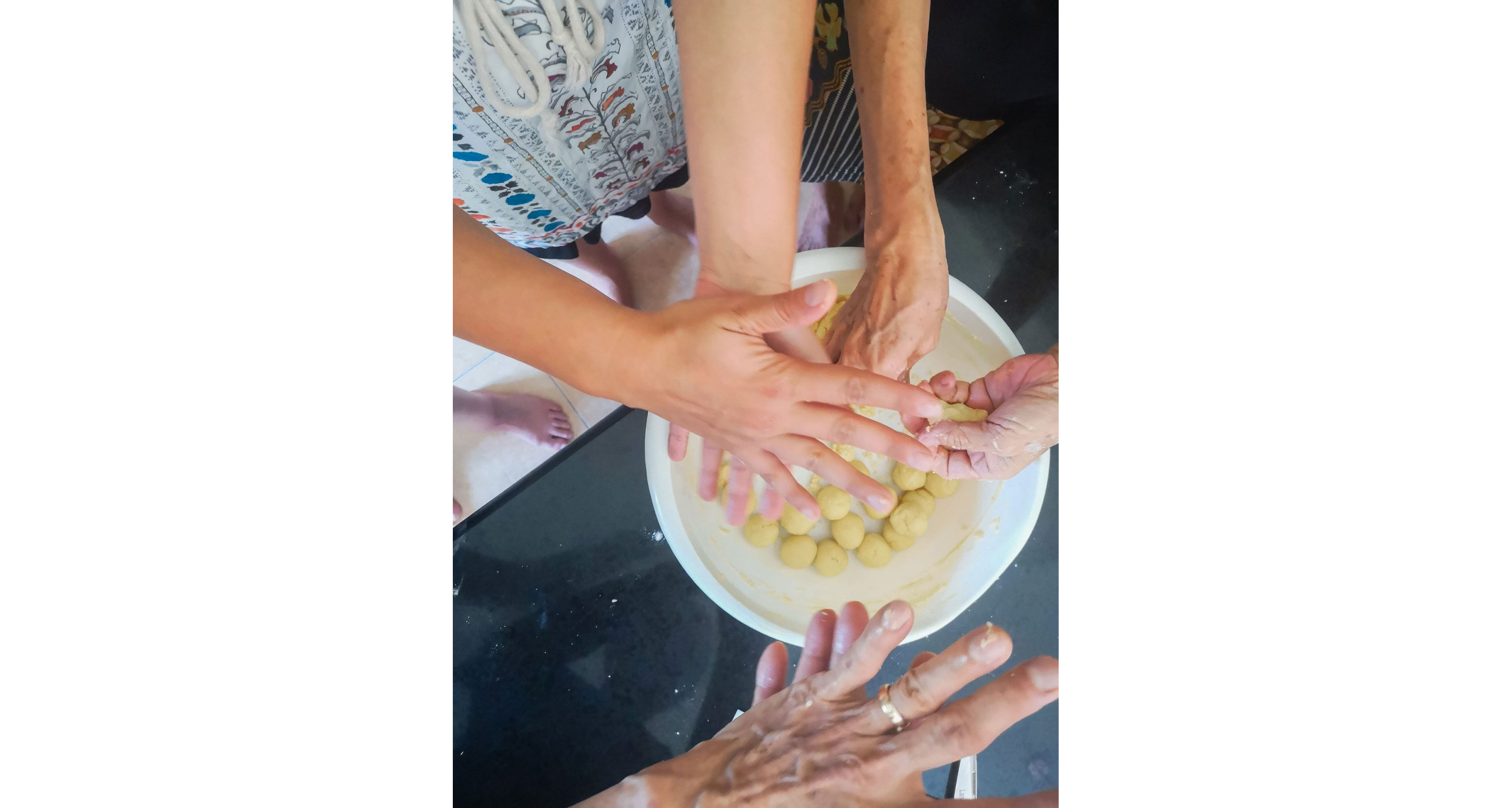 Gentle hands forming small balls of dough.