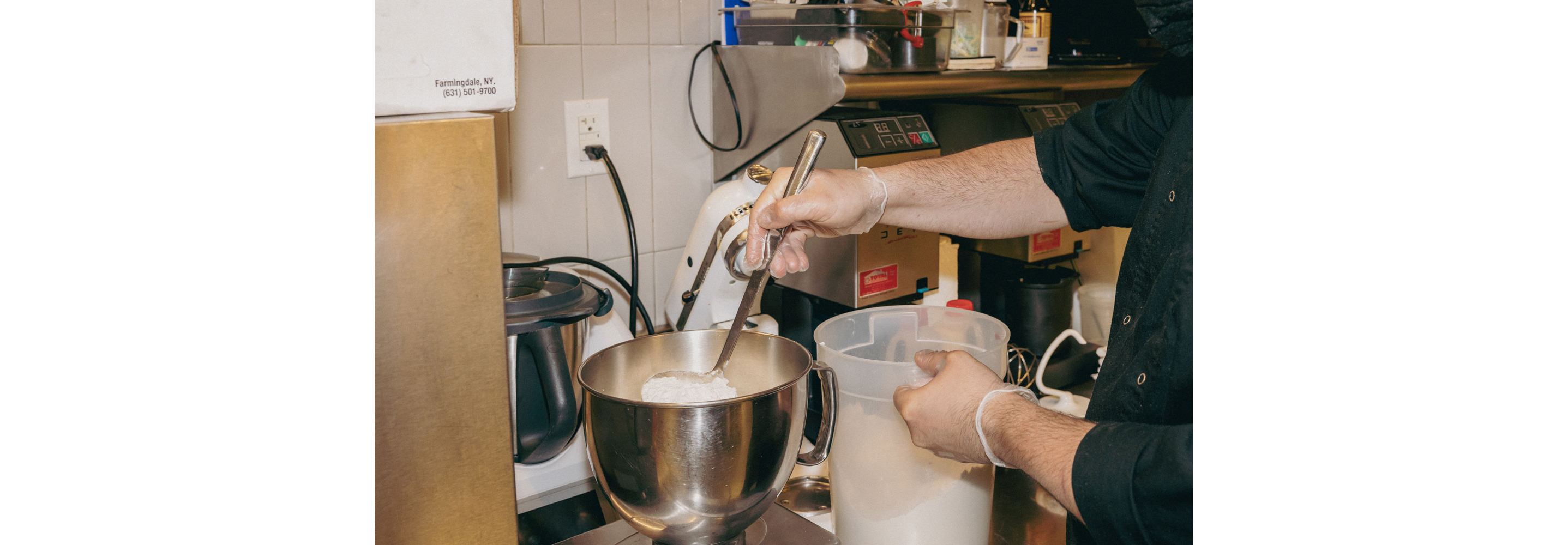 A person pouring flour into a bowl.