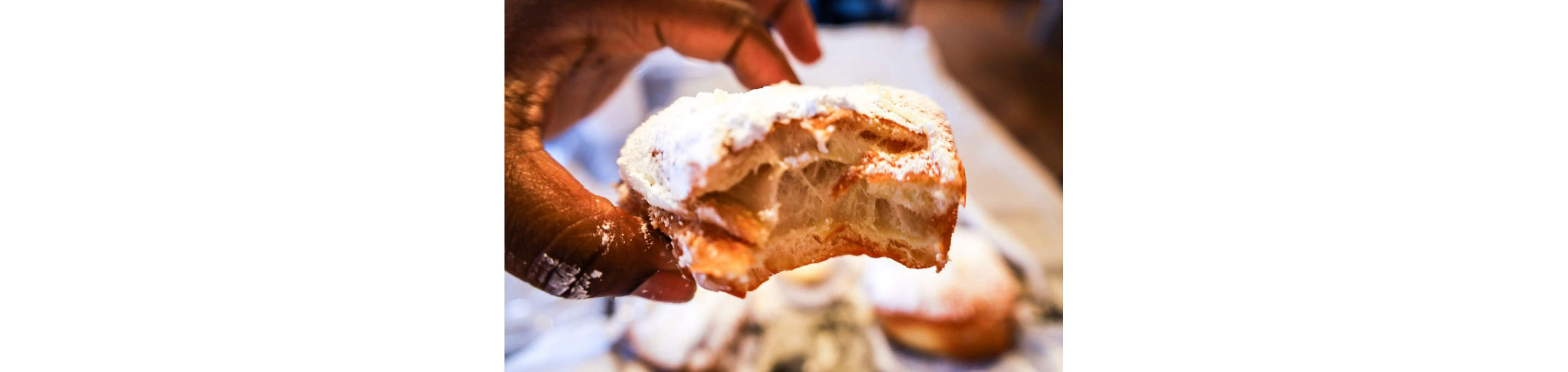 A person holding a beignets.