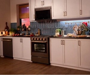 A KitchenAid® microwave, dishwasher, range and refrigerator in a dimly lit kitchen